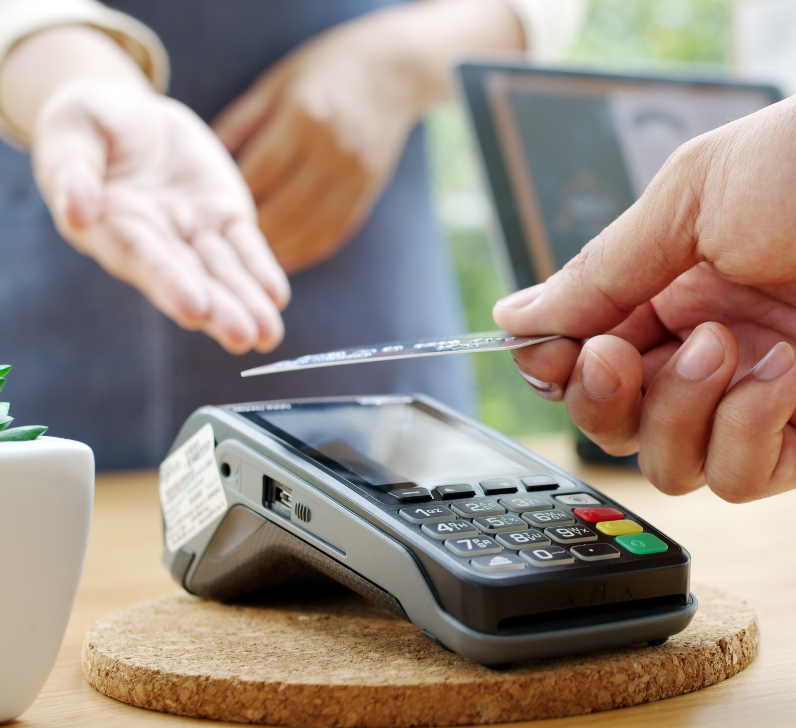 A person tapping their credit card onto a card reader