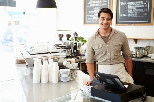 A barista standing behind the counter in a coffee shop